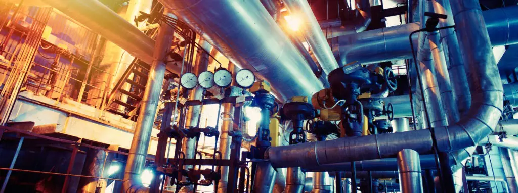 Industrial pipes and pressure gauges in a factory setting.